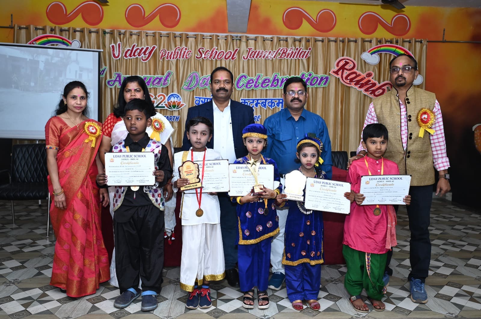 Prize-winning students holding trophies and certificates